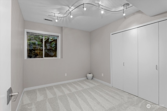 unfurnished bedroom featuring light carpet and a closet