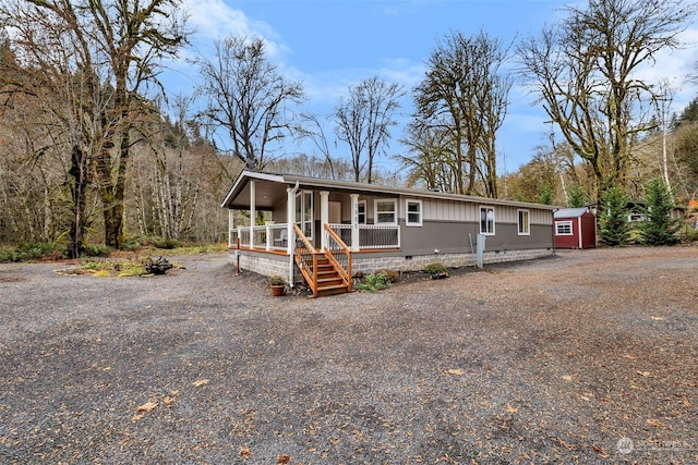 manufactured / mobile home featuring a storage unit and covered porch