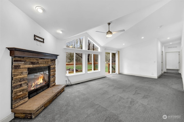 unfurnished living room with a stone fireplace, ceiling fan, carpet floors, and lofted ceiling