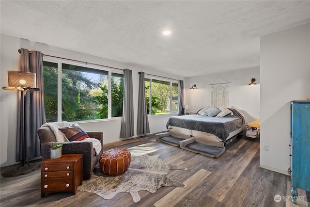 bedroom with a textured ceiling and dark hardwood / wood-style floors