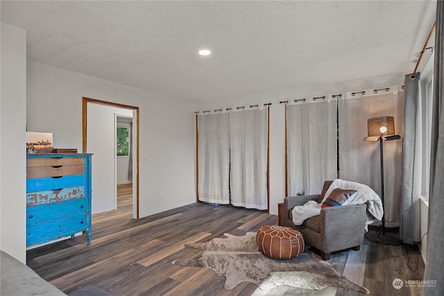 sitting room with a textured ceiling and dark hardwood / wood-style floors