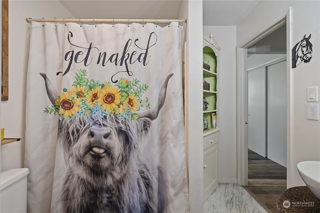 bathroom with a shower with curtain, hardwood / wood-style flooring, and toilet