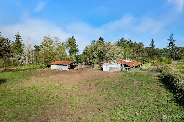 view of yard featuring a rural view and an outbuilding