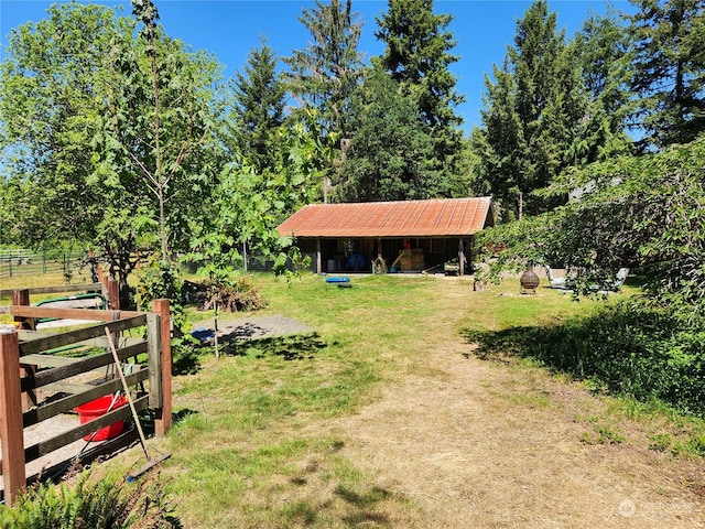 view of yard with an outdoor structure and a rural view