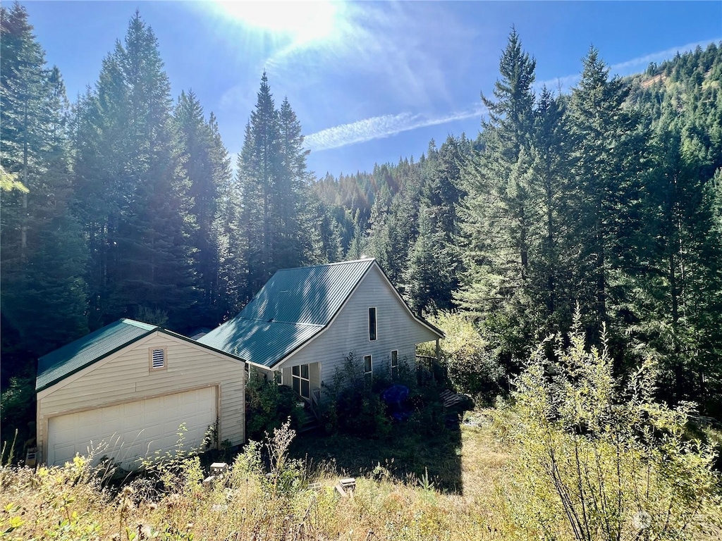 135 Burnt Fork Ln, Dayton, WA 99328 - view of side of property with a forest view, a garage, and an outbuilding