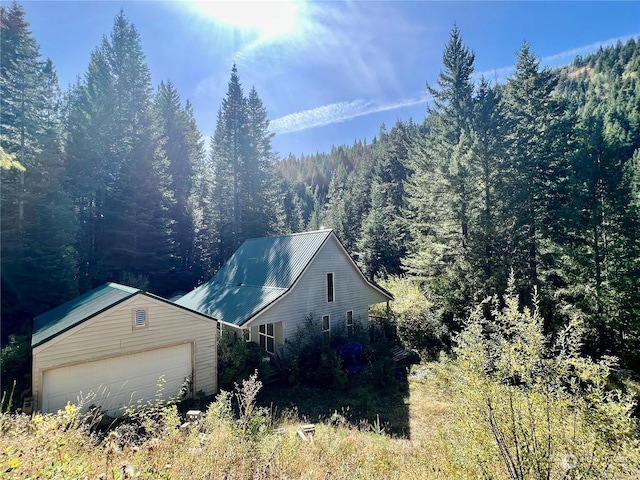 135 Burnt Fork Ln, Dayton, WA 99328 - view of side of property with a forest view, a garage, and an outbuilding