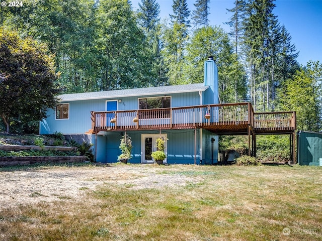 rear view of property featuring a yard and a wooden deck