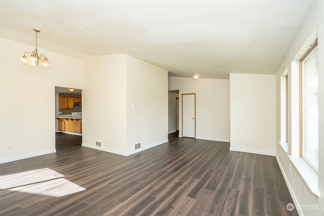 unfurnished room with vaulted ceiling, a chandelier, and dark wood-type flooring