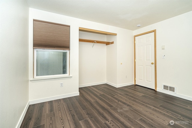 unfurnished bedroom featuring a closet and dark hardwood / wood-style flooring