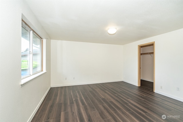 empty room with a textured ceiling and dark hardwood / wood-style floors