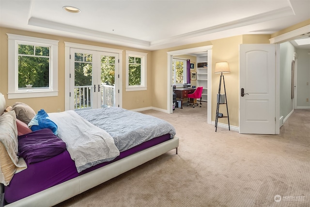 carpeted bedroom featuring french doors, a raised ceiling, and access to outside