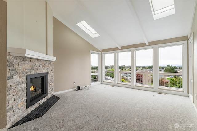 unfurnished living room featuring carpet floors, a fireplace, a skylight, and high vaulted ceiling