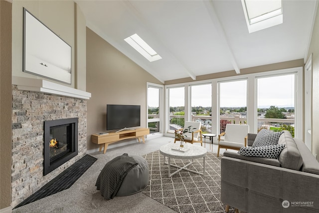 living room with high vaulted ceiling, a skylight, carpet floors, and a fireplace