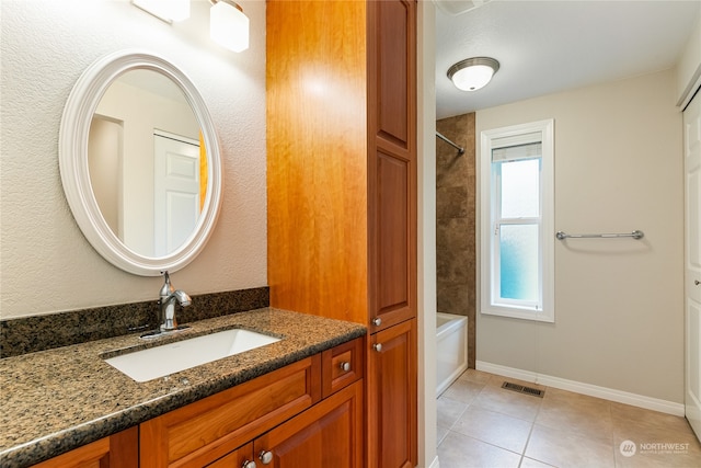 bathroom with tile patterned floors, tiled shower / bath, and vanity