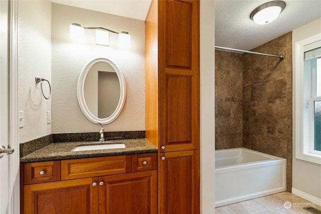 bathroom featuring a textured ceiling, vanity, tile patterned floors, and tiled shower / bath