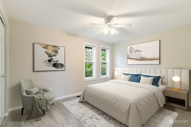 bedroom featuring light carpet, ceiling fan, and a closet