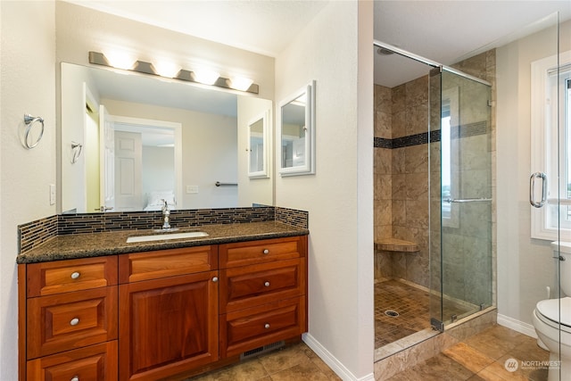 bathroom with vanity, toilet, tile patterned floors, and a shower with door