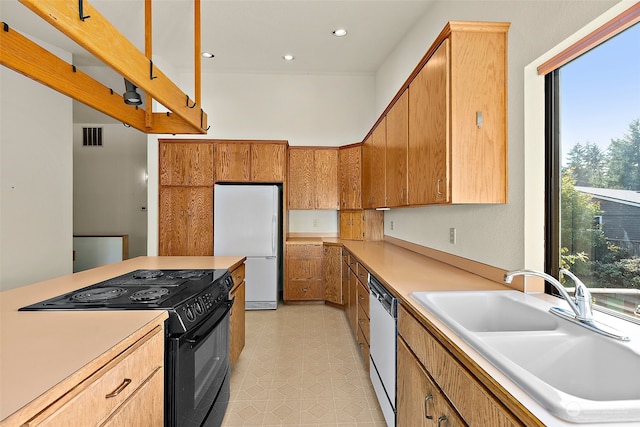 kitchen with white appliances, a healthy amount of sunlight, and sink