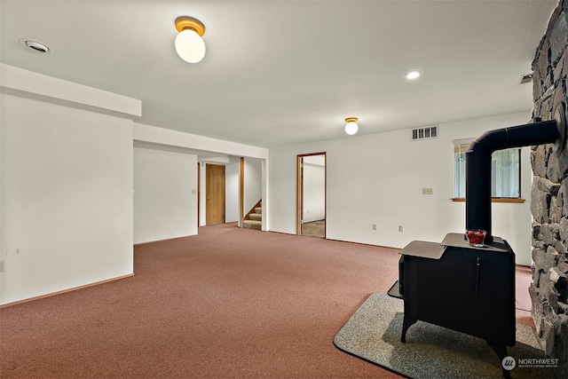 basement featuring a wood stove and carpet floors