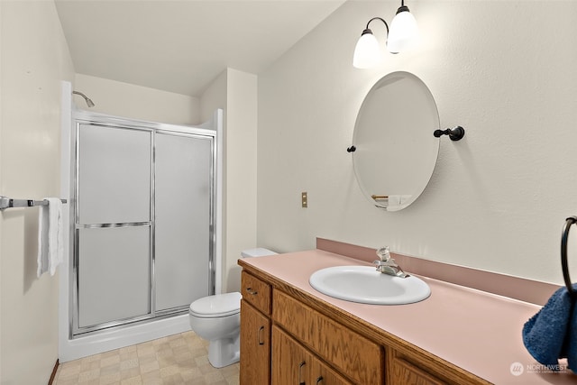 bathroom featuring vanity, toilet, and an enclosed shower