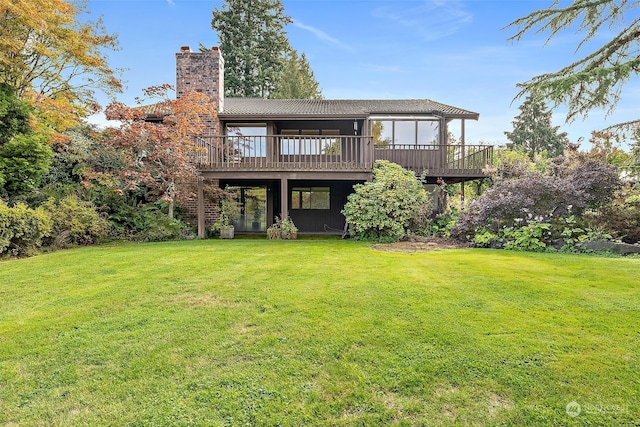 rear view of house featuring a lawn and a wooden deck