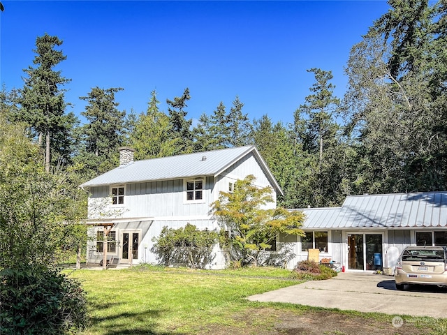 rear view of house featuring a lawn, a carport, and covered porch