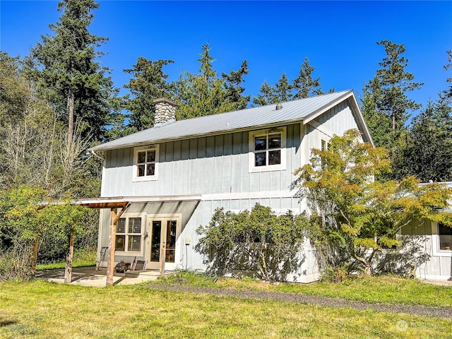 back of house featuring a lawn and a patio area