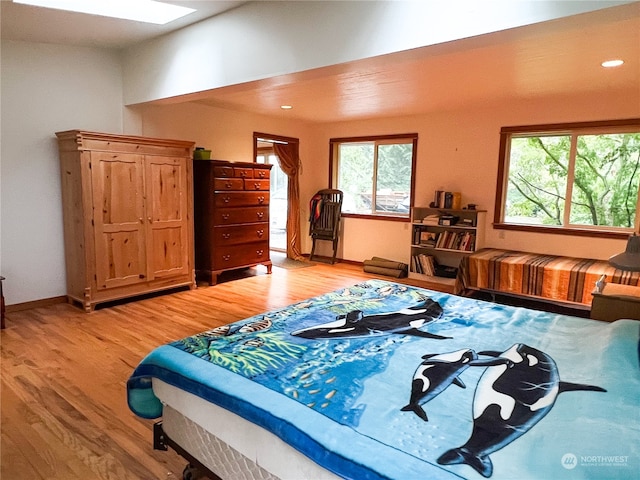 bedroom with wood-type flooring and a skylight