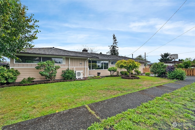 view of front of home featuring ac unit and a front lawn