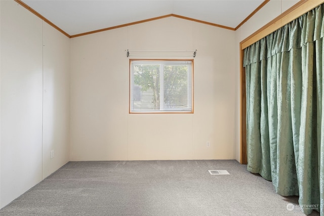 spare room featuring crown molding, vaulted ceiling, and carpet