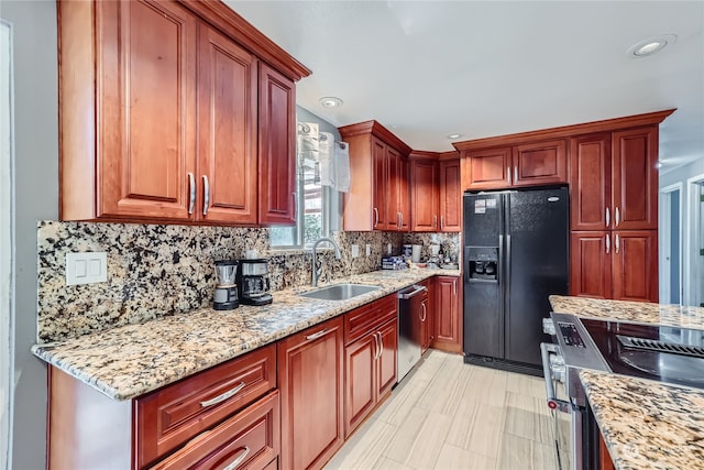 kitchen featuring light stone counters, stainless steel appliances, sink, and tasteful backsplash