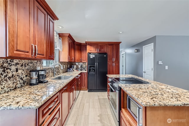 kitchen with light stone countertops, appliances with stainless steel finishes, backsplash, and sink