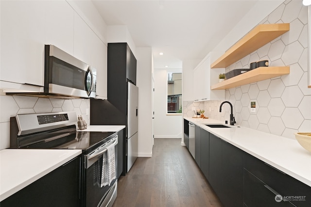 kitchen with hardwood / wood-style floors, sink, stainless steel appliances, and white cabinets