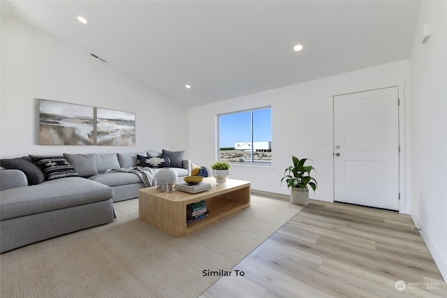 living room featuring light hardwood / wood-style floors and vaulted ceiling