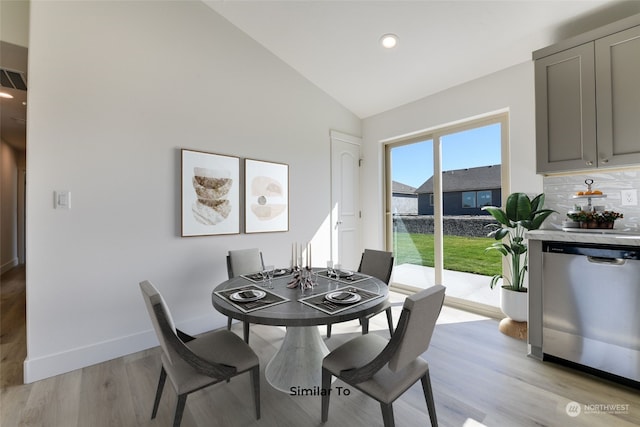 dining area featuring light hardwood / wood-style flooring and vaulted ceiling