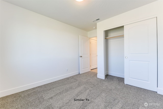 unfurnished bedroom featuring light colored carpet and a closet