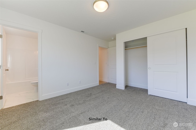 unfurnished bedroom with a closet, carpet floors, and ensuite bathroom