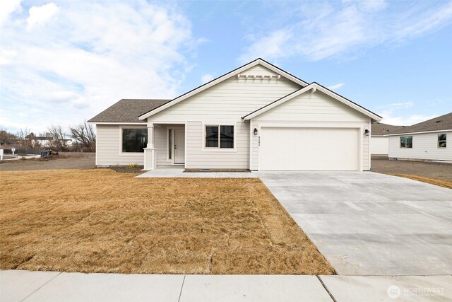 single story home featuring driveway, roof with shingles, an attached garage, and a front yard