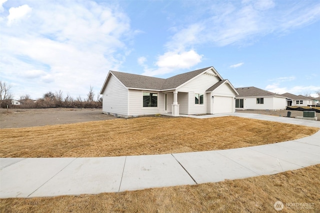 view of front of property featuring a front yard, concrete driveway, and an attached garage