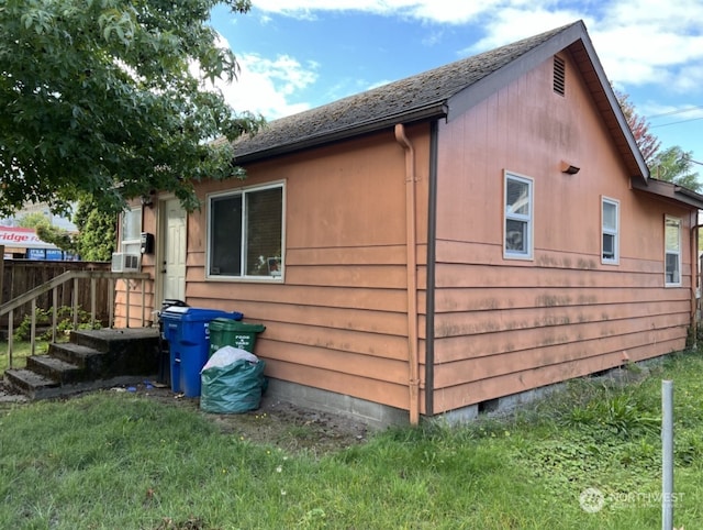 view of home's exterior featuring cooling unit and a yard