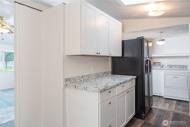 kitchen featuring a ceiling fan, white cabinets, black fridge, dark wood-style floors, and washer and clothes dryer