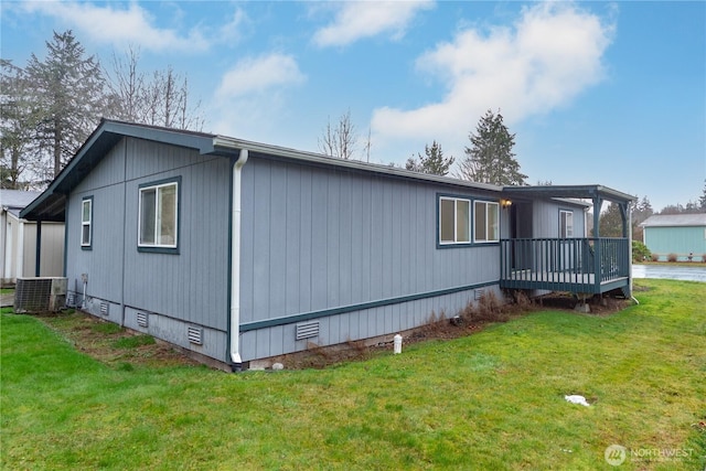 view of side of property featuring a deck, a yard, crawl space, and central AC