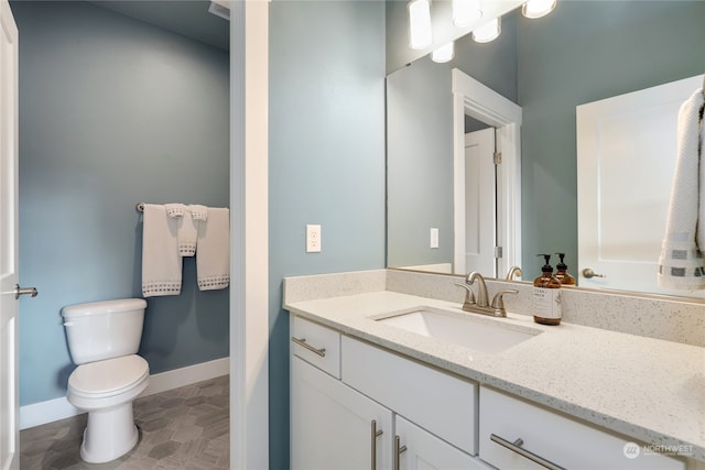 bathroom featuring vanity, tile patterned flooring, and toilet