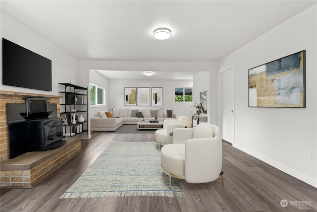 living room with dark wood-type flooring and a wood stove