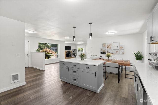 kitchen with hanging light fixtures, a center island, dark wood-type flooring, and gray cabinets