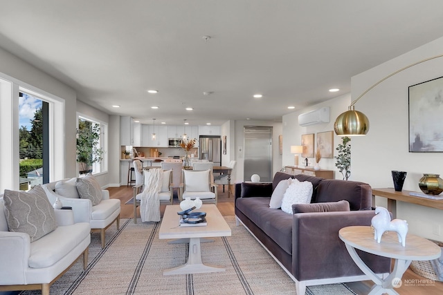 living room with light hardwood / wood-style floors and a wall mounted air conditioner