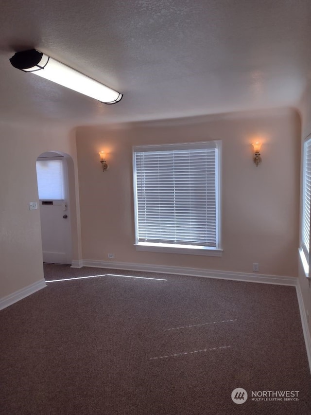 unfurnished room featuring a textured ceiling and carpet floors