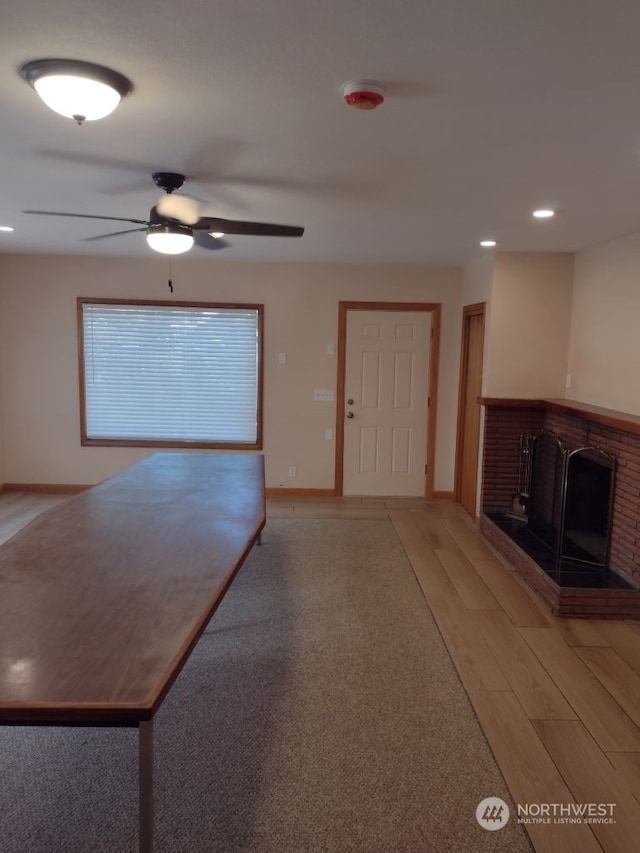 interior space featuring ceiling fan, hardwood / wood-style flooring, and a fireplace