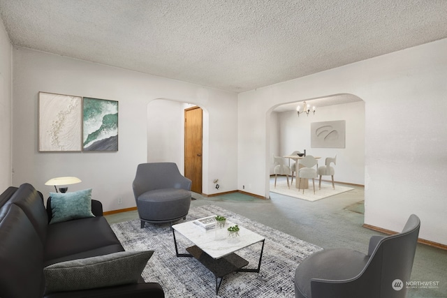 living room with a notable chandelier, carpet, and a textured ceiling