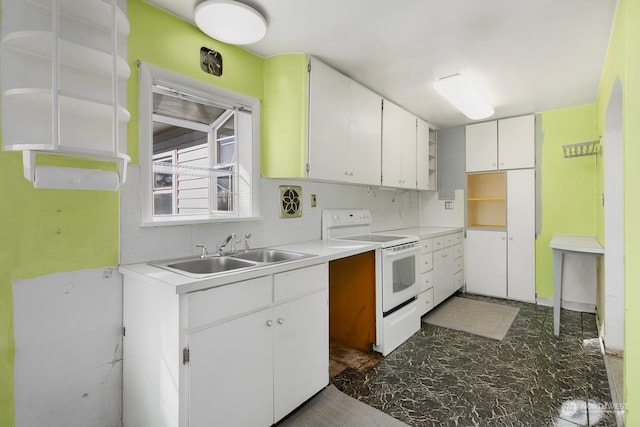 kitchen with electric stove, sink, and white cabinets